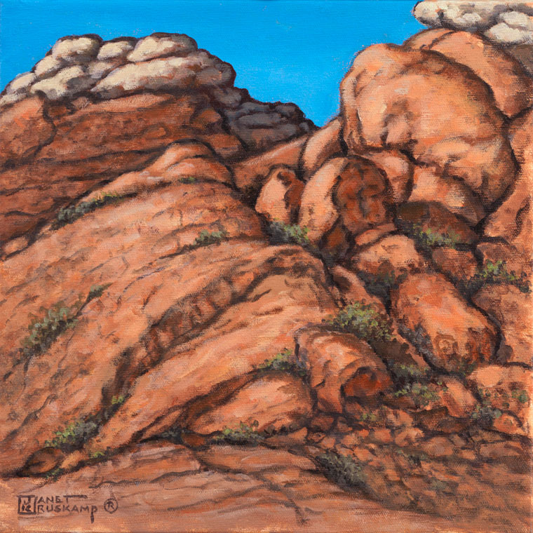 Red Rock Canyon #1, a landscape painting from artist Janet Kruskamp incorporating the red desert sandstone of the American southwest. Hardy plants cling to the cracks in the weathered canyon wall rising up to a lighter colored rock at the top of the wall. One of the Interiors and Exteriors Gallery by Janet Kruskamp.